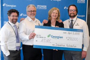 Three men and a woman holding a big cheque for $250,000