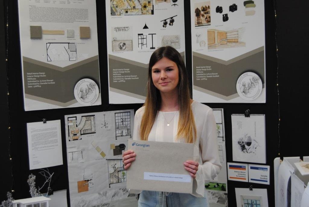 Danielle Horsfield standing beside her project at the Design and Visual Arts show
