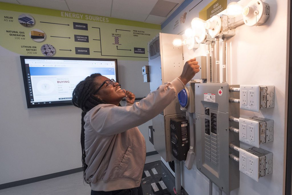 A women tests the control panel in the electrical lab in the Advanced Technology Centre at Georgian College.