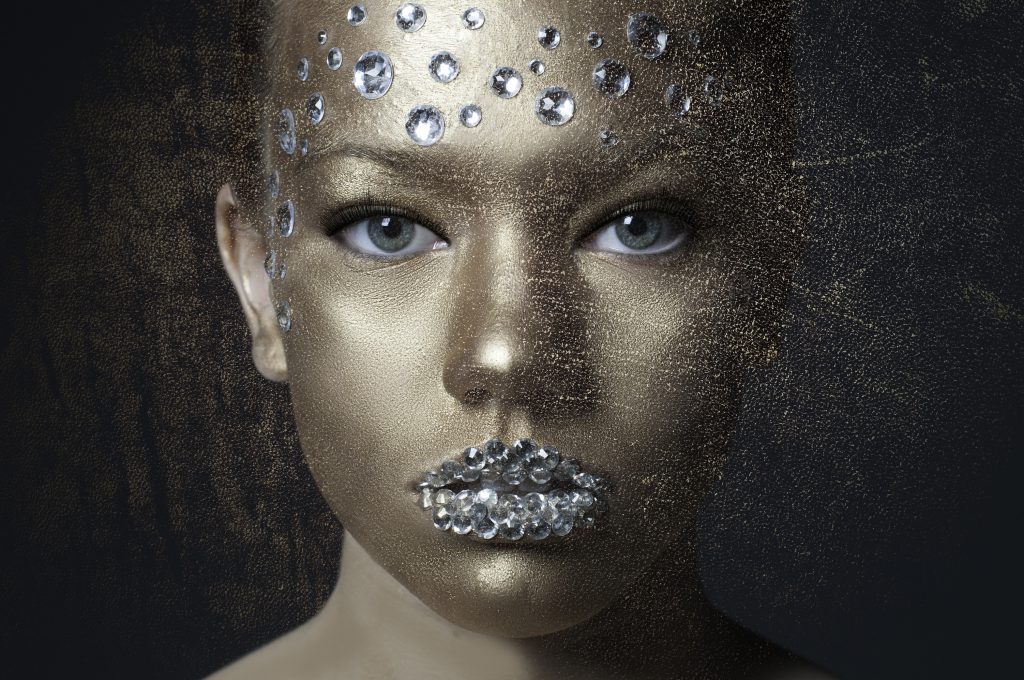Girl with gemstones on her head and lips with sparkles over her face