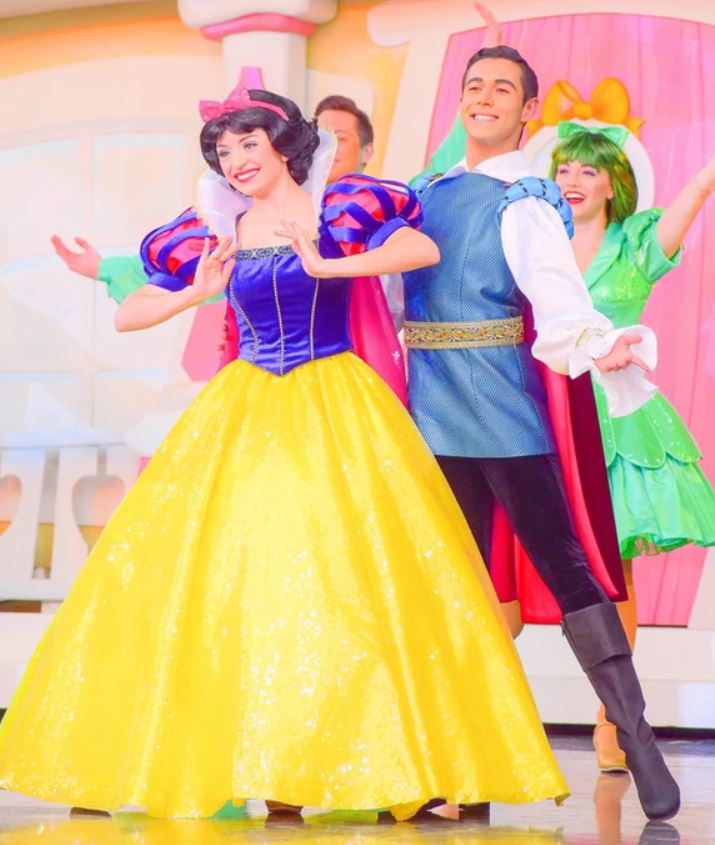 Four dancers on a stage dressed as Snow White, The Prince and other characters.