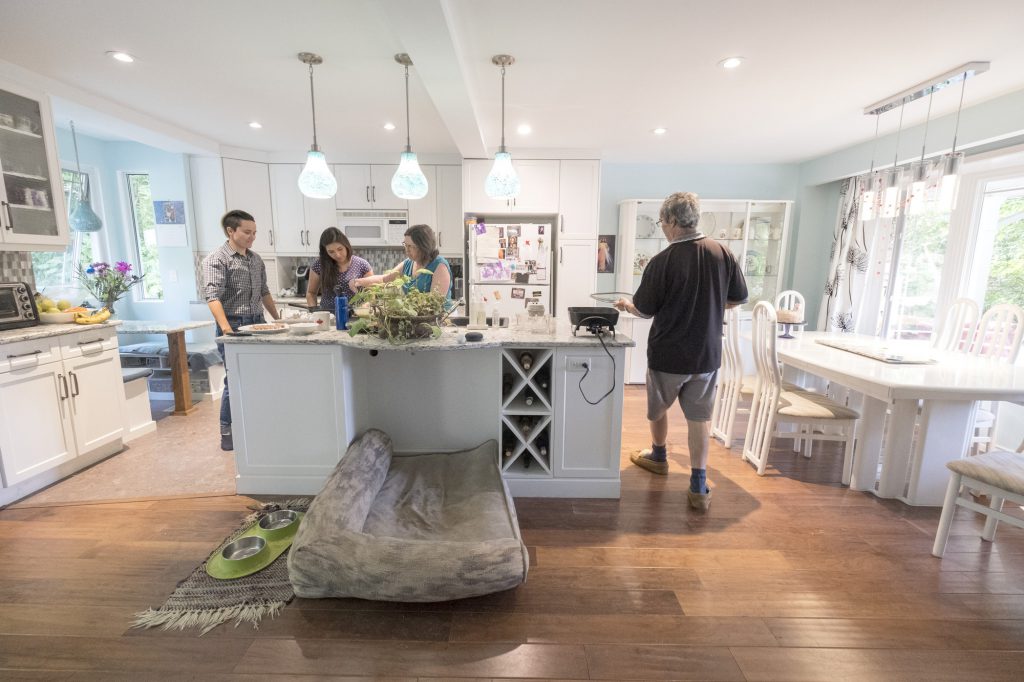 Two homestay parents and two homestay students work in a kitchen together