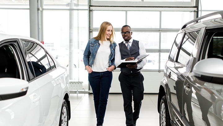 two young people in a automotive dealership
