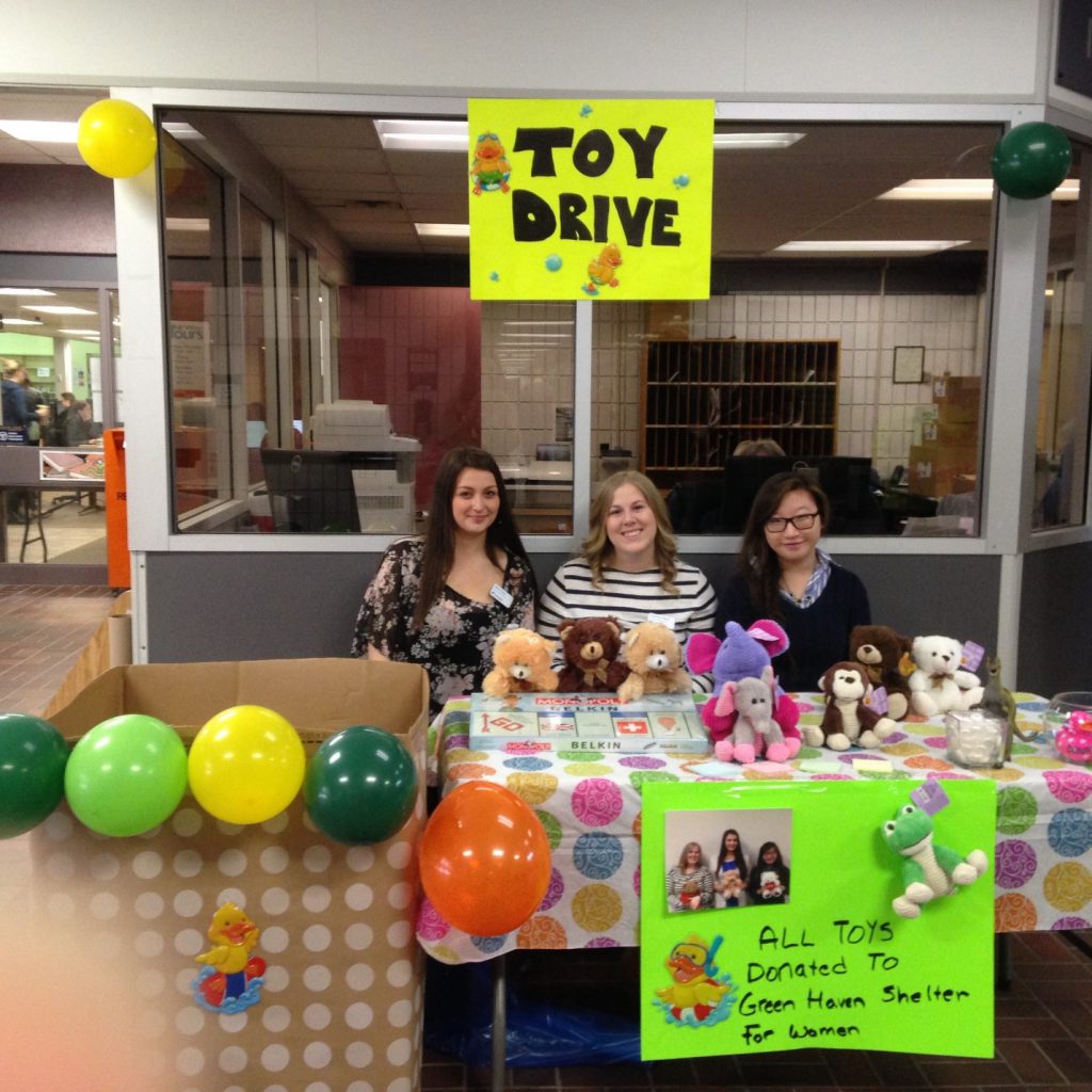 Girls sitting at Toy Drive table. Example of CSL in action.