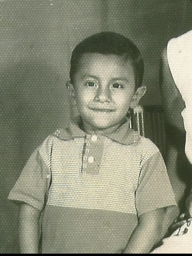 A black-and-white photo of a smiling child.