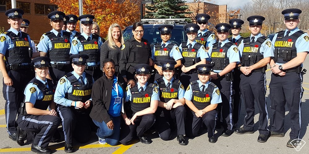 A group of people in police uniforms smile at the camera.