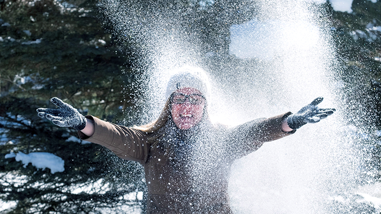 Georgian-Muskoka-Campus-staff-member-Michelle-Kennedy-throws-snow-in-the-air-and-smiles-at-the-camera-outside-the-campus-feature-shot