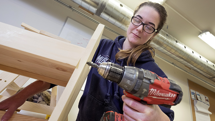 Georgian-Muskoka-Carpentry-and-Renovation-Techniques-students-Cari-Gillan-works-on-a-stool-in-the-benchroom