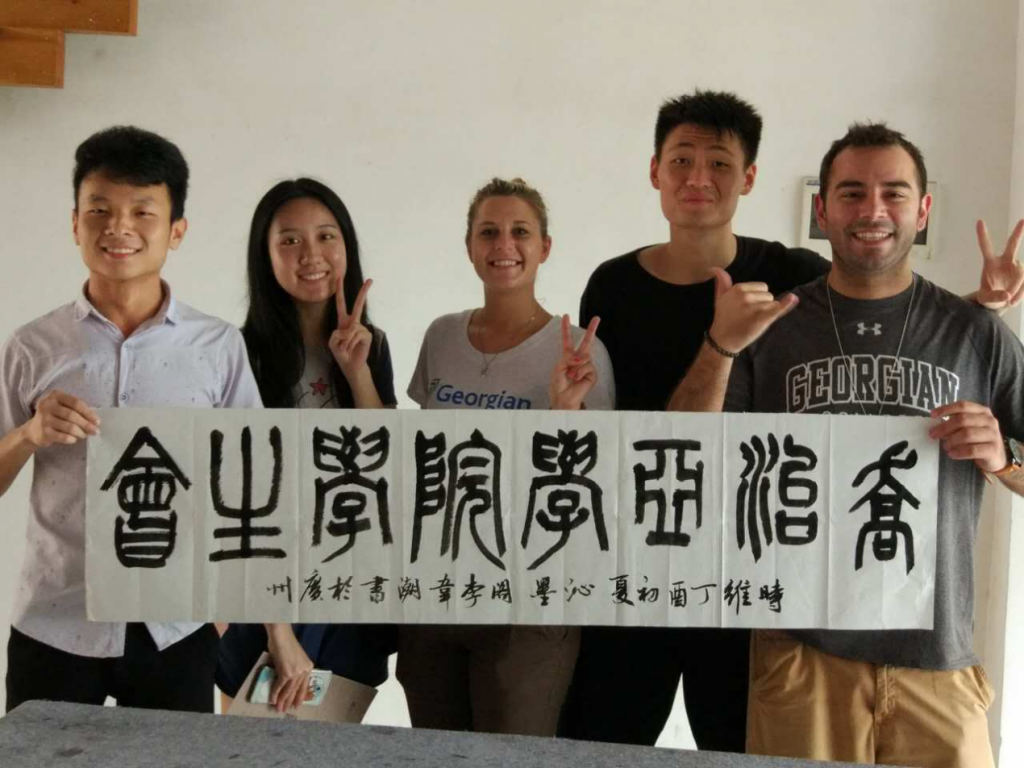 Melissa with Chinese students, holding a banner