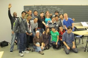 A group of international students poses in front of a blackboard