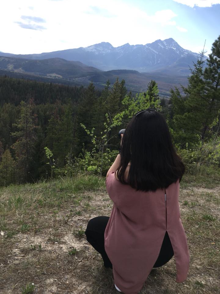 A woman taking pictures of mountains in British Columbia