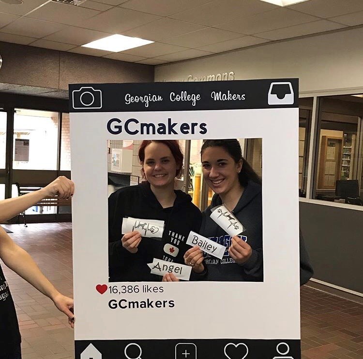 Students in an Instagram photobooth that says GC makers