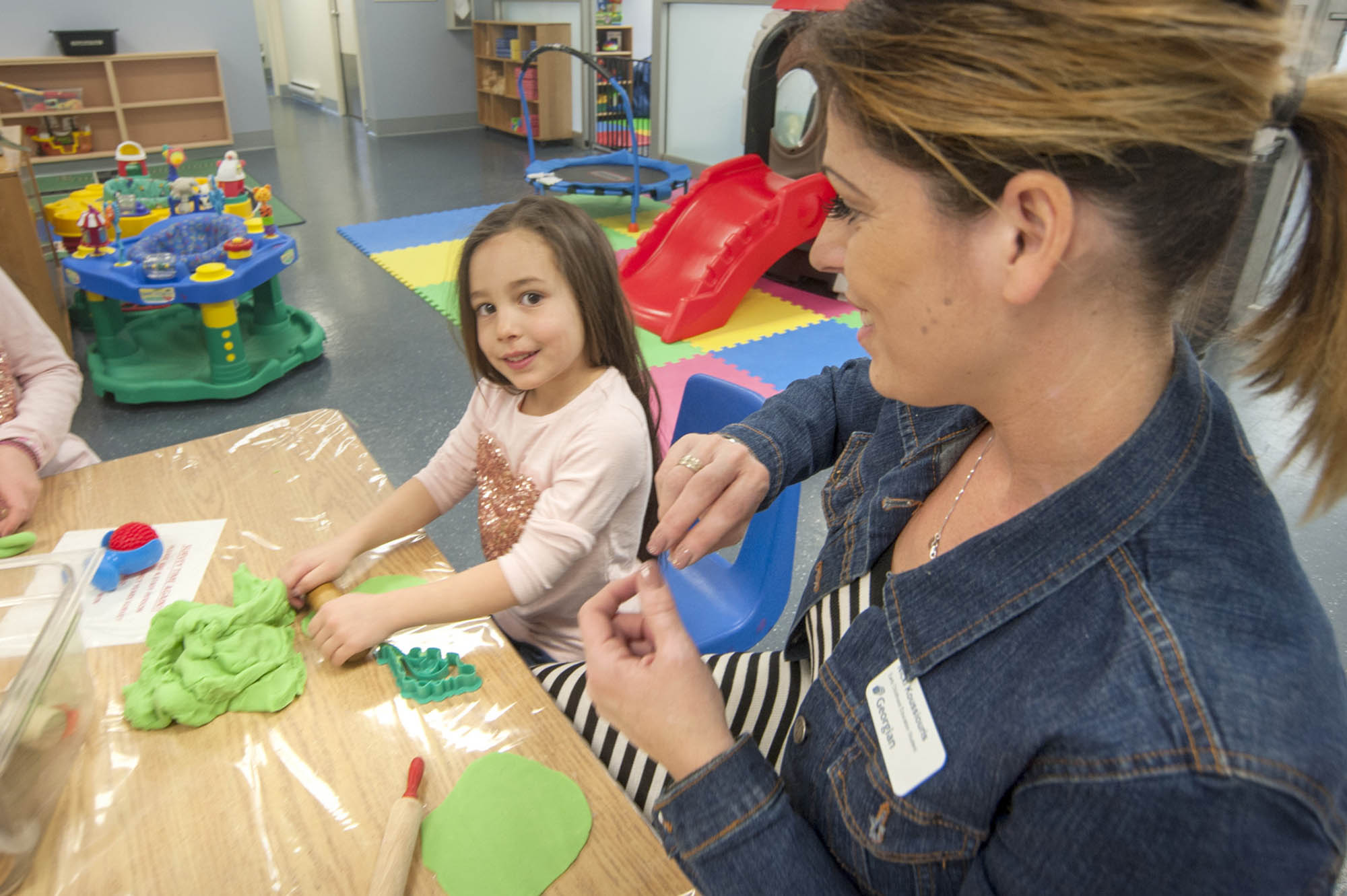 ECE student in a daycare centre with a young girl