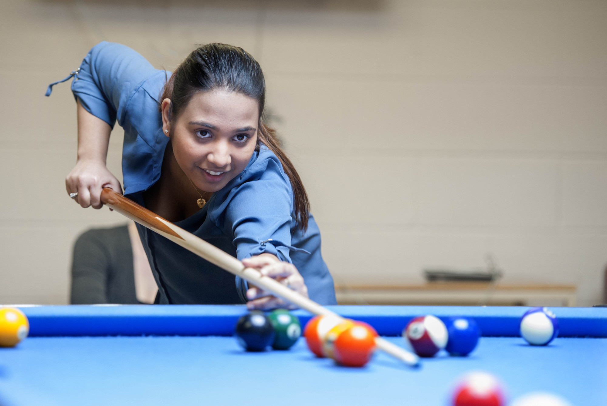 Young female student playing pool at the Orillia Campus