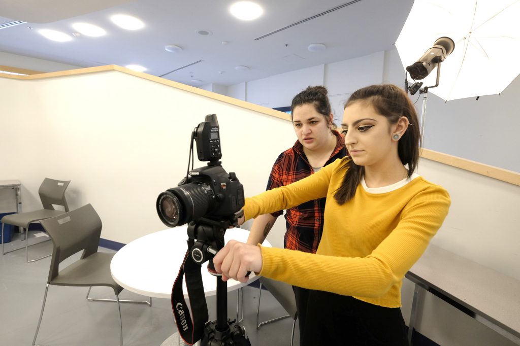 2 female students in a studio taking photos