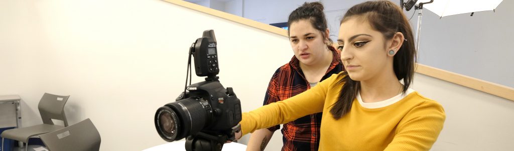 two photography students looking at camera