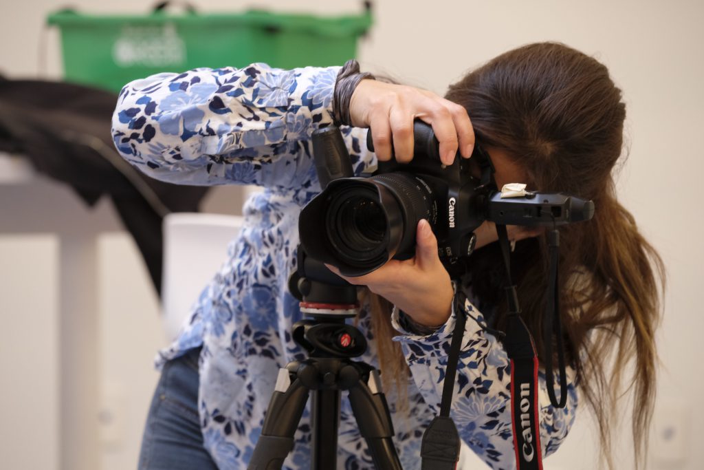 a female student using a Canon camera to take a photo