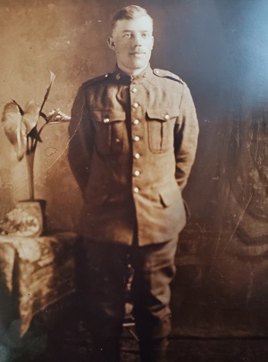 Solider standing in room; sepia coloured photo
