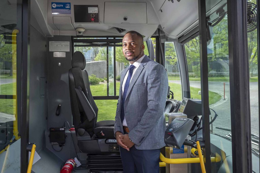Ronjay Clarke stands in the entrance of a bus