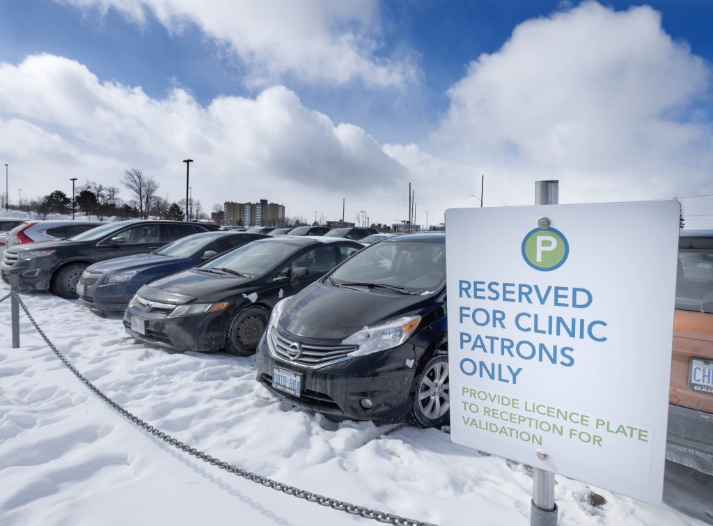 Cars parked in a line with a sign that says reserved for clinic patrons only