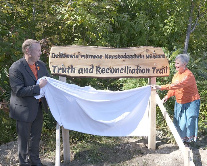 Kevin Weaver, President and CEO and Ernestine Baldwin, Visiting Elder, unveiling the new sign at the Truth and Reconciliation trail.