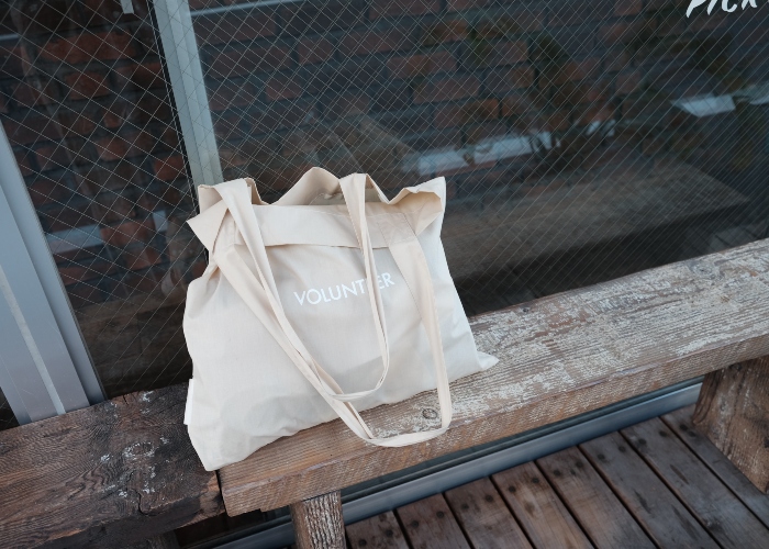 A beige tote bag on a bench