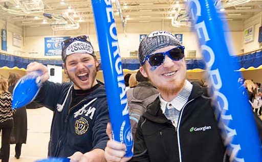 Two students at Orientation with Georgian-branded thundersticks and face paint