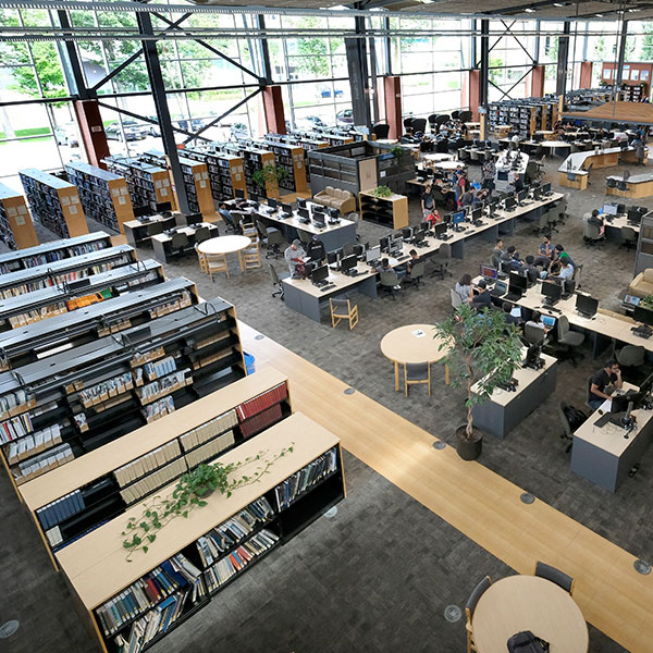 Top-down view of the Library at the Georgian College Barrie campus, featuring bookcases, computers and study tables