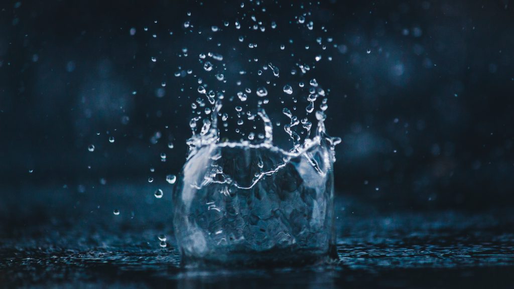 a close up of a water drop hitting a body of water