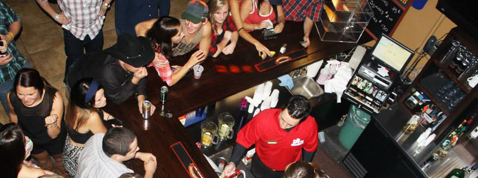 Students standing at and around the bar area inside The Den at Georgian College's Orillia Campus