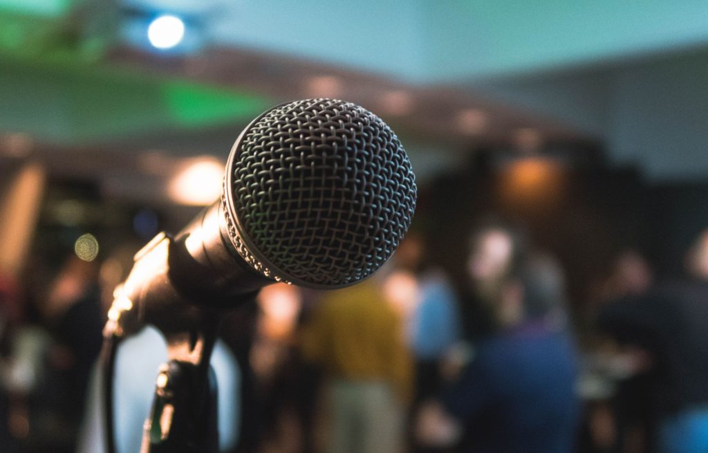 A microphone on stage in front of an audience
