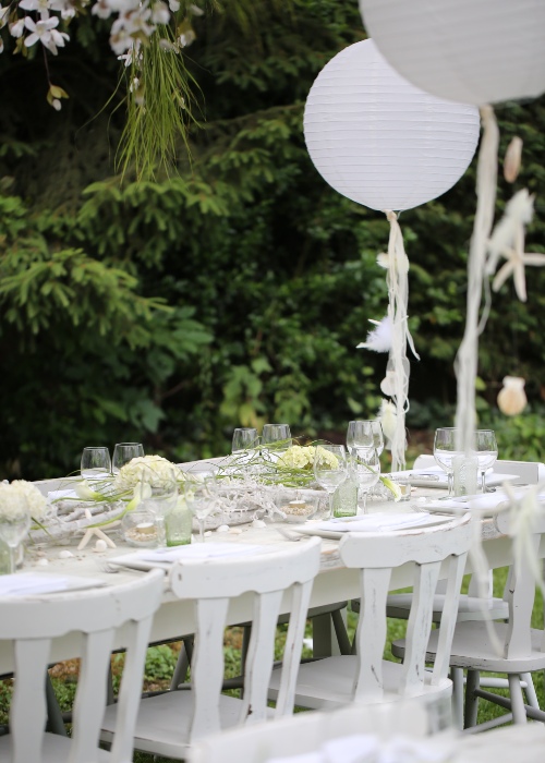 white table and chairs decorated for a wedding