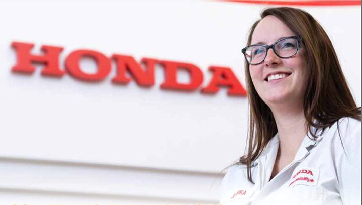 Jessica Kipis, Business Administration, Accounting, Class of 2011 wearing a Honda uniform while standing in front of a Honda sign