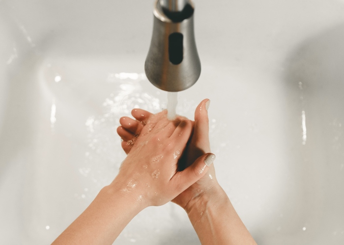 hands getting washed under a tap