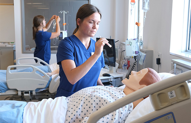 BScN students Martha and Anna Koski practising pupil reflex and intravenous medication administration at the Barrie Campus nursing lab