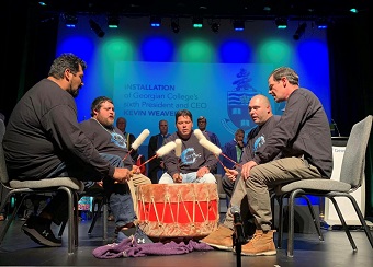 At installation of President and CEO Kevin Weaver, Ashunyung singers from Chippewas of Georgina Island First Nation perform an honour song on stage with drum