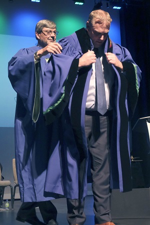 Board Chair places new gown on President and CEO