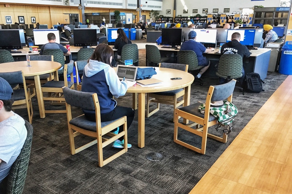 Some groups of tables and chairs, with computers, at the library