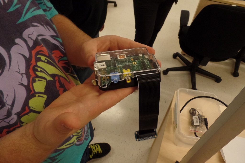 A student holding a piece of technology they made in the makers space