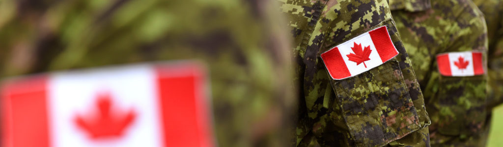 Soldiers in uniform with a Canadian flag patch sewn onto the arm