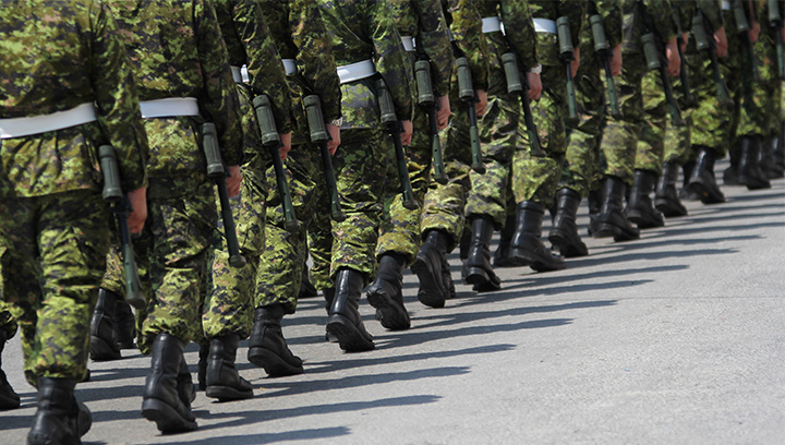 Canadian military soldiers in uniform marching in a row