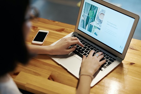 Person using macbook pro, stock image, remote courses