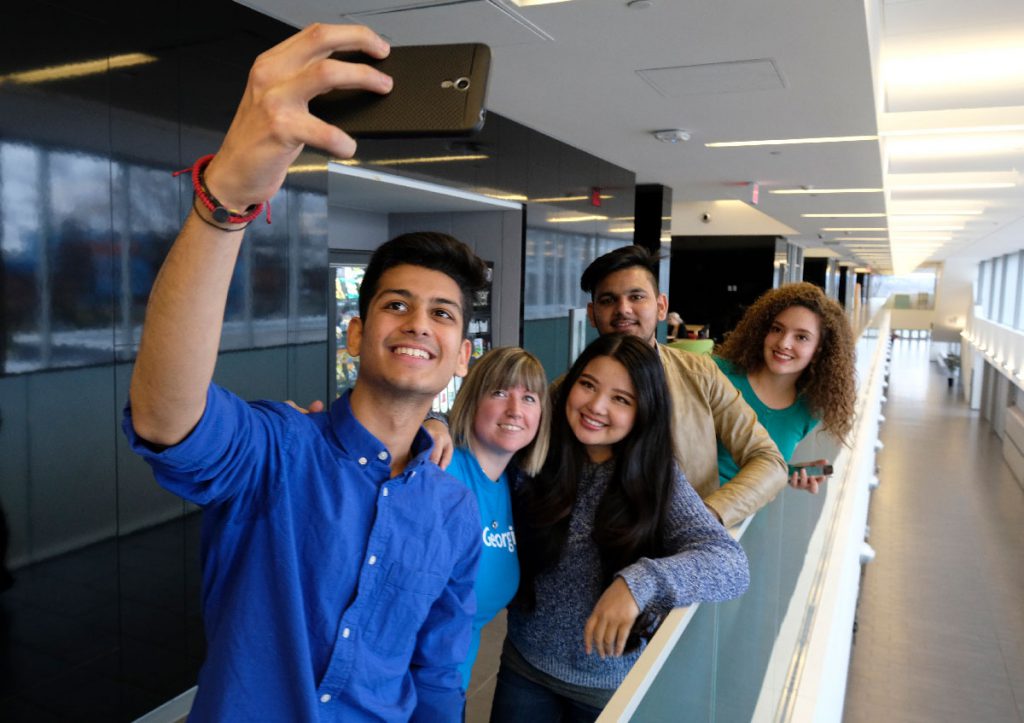 a group of female and male students taking a selfie inside the Sadlon Centre for Health and Wellness at Georgian's Barrie Campus