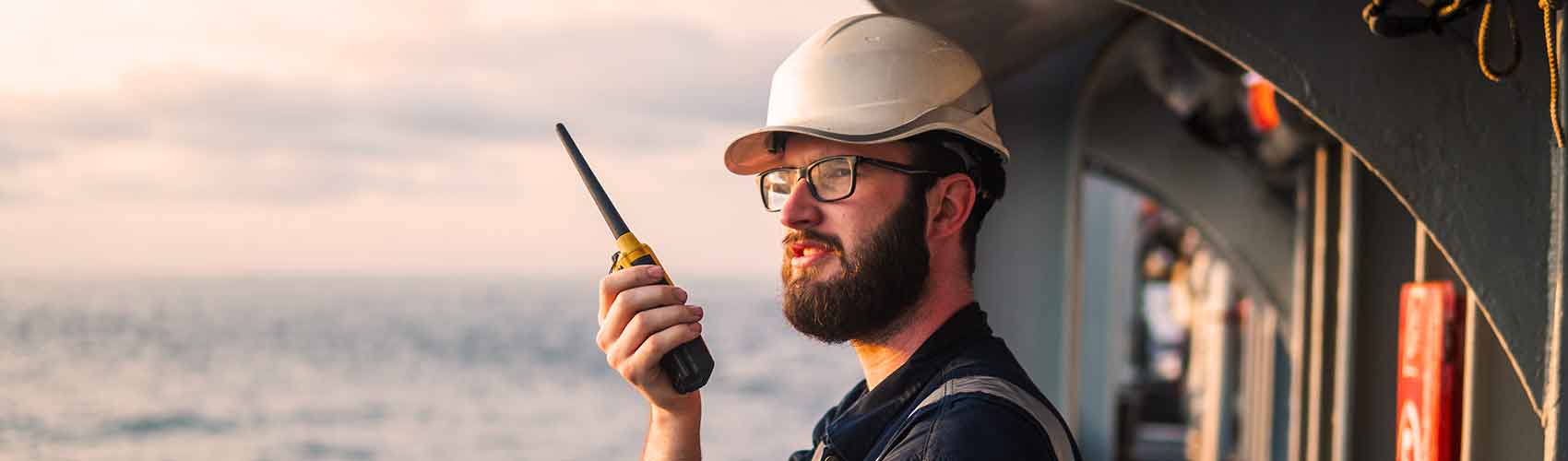 Commercial sailor on the deck of a ship withr radio
