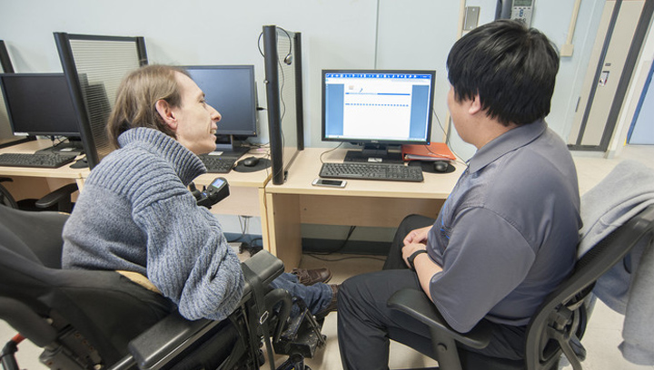 an accessibility advisor assisting a student with adaptive technology