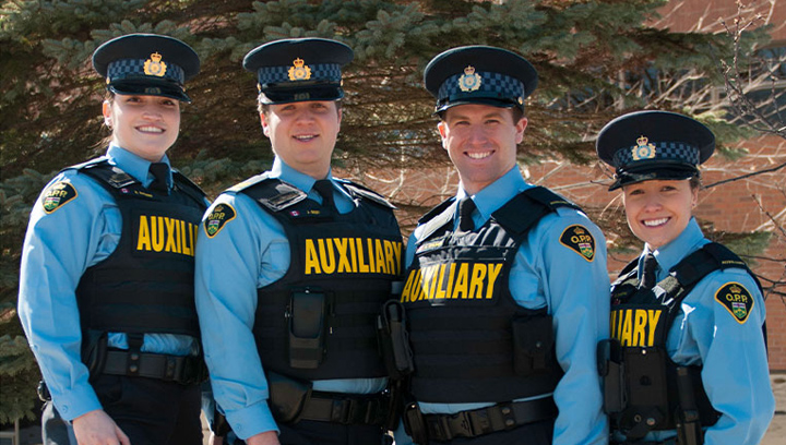 four Police Foundations students standing outside wearing OPP Auxiliary uniforms