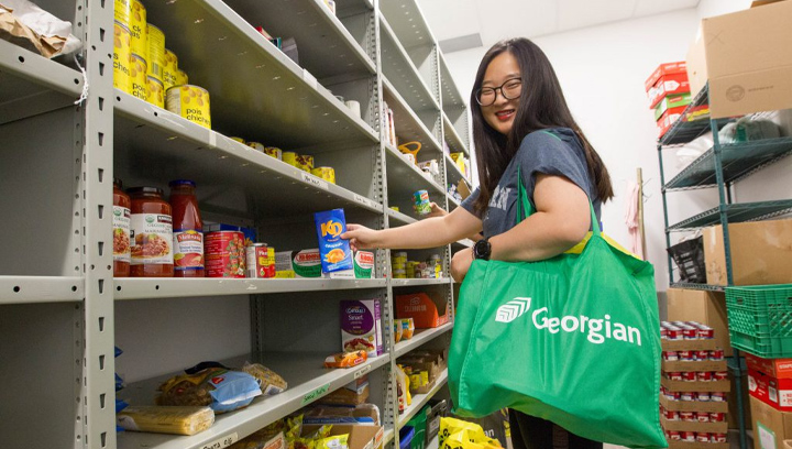 a student with a Georgian green reusable bag grabbing some food from a shelf