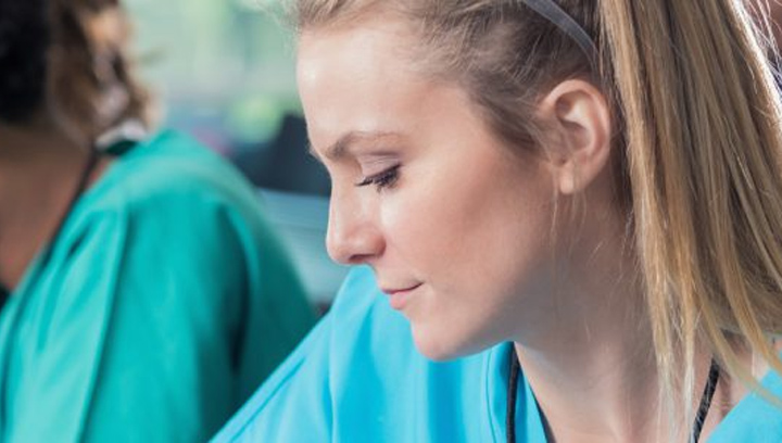 a female student wearing blue medical scrubs