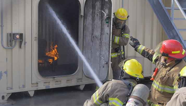Marine cadets practicing fighting a fire in a simulated commercial ship