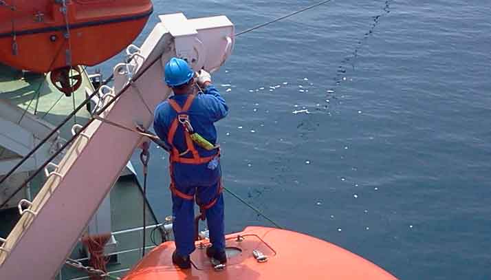 Marine engineer repairing the winch of a life boat on a commercial ship